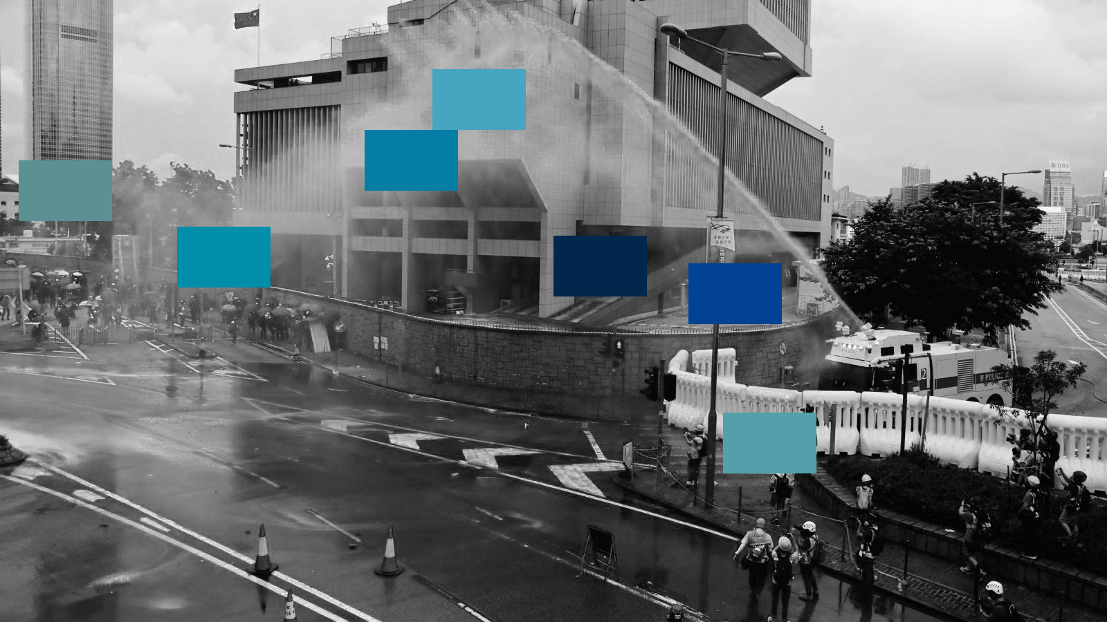 A black-and-white photo of a water cannon shooting water onto the streets with swatches of blue overlaid on top